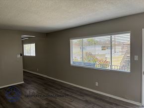 Anaheim apartment for rent - A room with a window showing a view of a building and trees.